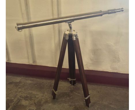 A chrome telescope on beech tripod stand 