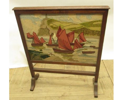 C20th oak framed fire screen with inset needle work panel of fishing vessels 