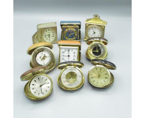 Rhythm world time travel alarm clock in clam shell leatherette case and a collection of other similar travel clocks 