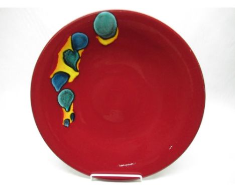 Large Poole pottery Odyssey charger, with turquoise blue and orange random decoration on a deep red ground, printed marks, D4