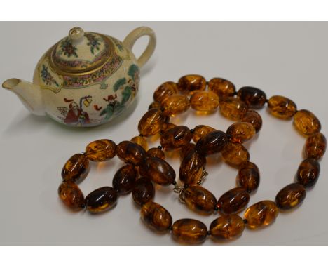 A VINTAGE STRING OF AMBER EFFECT BEADS, TOGETHER WITH A MINIATURE ORIENTAL LIDDED TEAPOT     