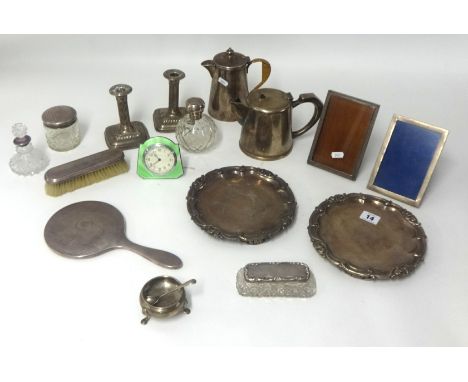 Three silver photo frames, pair silver desk candlesticks, silver top scent bottle, silver table salt, two silver top jars and