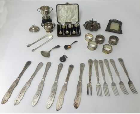 Various items including silver ring stand, two ornate silver napkin rings and three others (4oz), sugar tongs, white metal ca