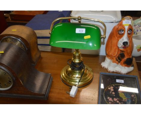 A brass desk lamp with green glass shade