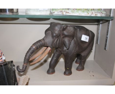 A carved wooden elephant ornament with articulated trunk