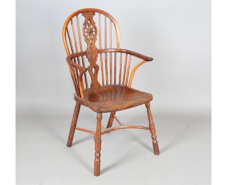 An early Victorian yew and elm stick and wheel back Windsor armchair with shaped panel seat and crinoline stretcher, height 9