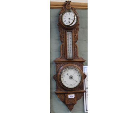 A carved oak aneroid barometer/clock