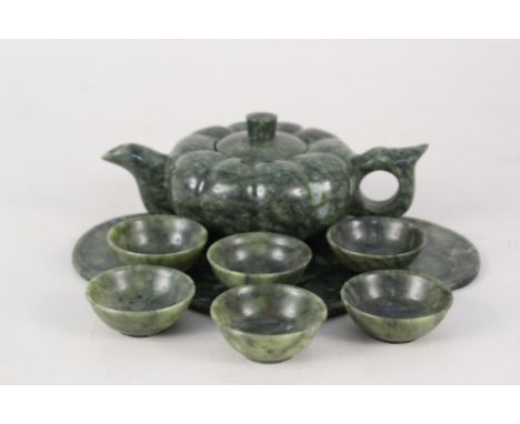 A Chinese spinach jade wine pot of compressed shape with six bowls and shaped tray