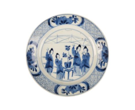 BLUE AND WHITE DISH NARRATIVE DISH, KANGXI PERIOD decorated with four ladies around a central table, within a foliate and dia
