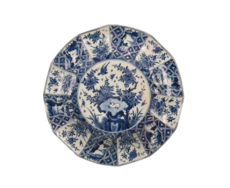 BLUE AND WHITE DODECAGONAL DISH, KANGXI PERIOD, the centre painted with a hare on a rock among flowers, within an alternating