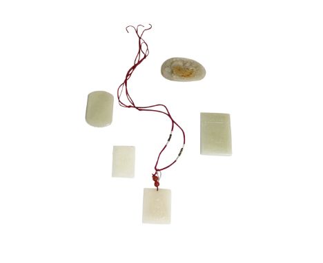 FOUR CARVED JADE PENDANTS, largest, 6.5cm high; together with a JADE PEBBLE CARVING, 7cm wide (5)