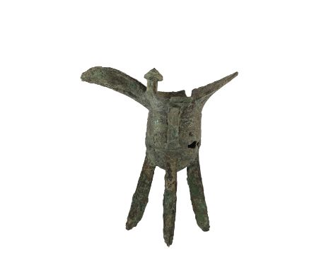 BRONZE JUE-FORM TRIPOD RITUAL VESSEL, SHANG DYNASTY, the long spout with a notched flange, facing a pointed tail on the oppos