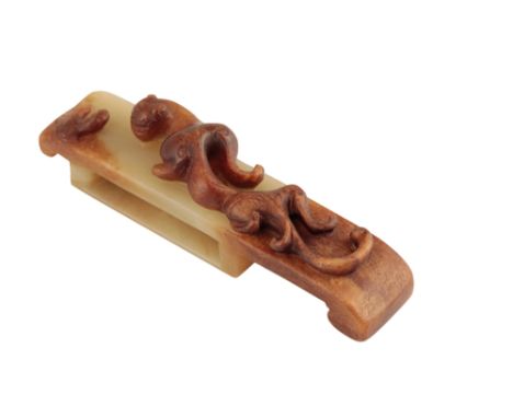 CELADON AND BROWN JADE 'CHILONG' SWORD SLIDE, MING DYNASTY, of scroll form, the upper surface carved in relief with a chilong