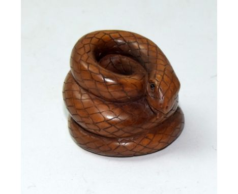 A Japanese hardwood netsuke in the form of a coiled snake signed to the base