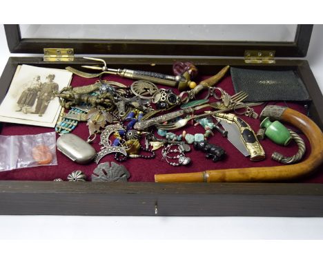 A table top display unit with a collection of curiose to include walking stick handle, post cards and misc. jewellery