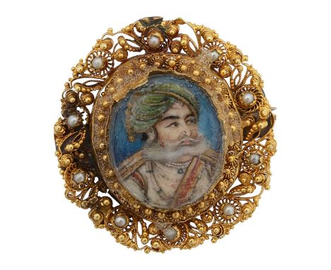 A 19th century Indian portrait miniature broochdepicting a Mughal ruler, watercolour on ivory, glazed, oval, cannetille work 