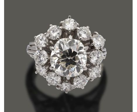 A diamond flowerhead cluster ringthe centurial cushion-shaped old brilliant-cut diamond weighing approx 2.87ct to the two tie