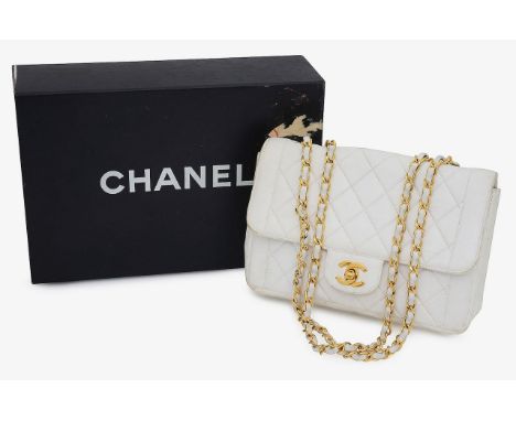 A leather quilted cream coloured Chanel handbag featuring a rectangular body with classic quilted effect stitching, a front f