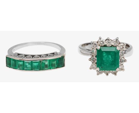 An emerald and diamond-set cluster ring and another the rectangular cut cornered emerald within a border of brilliant-cut dia