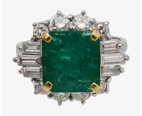 An emerald and diamond-set cluster ringthe rectangular cut-cornered emerald claw-set above the border of eight brilliant-cut 