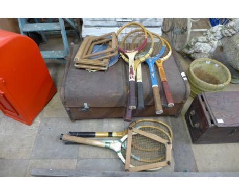 A steamer trunk and various vintage tennis racquets