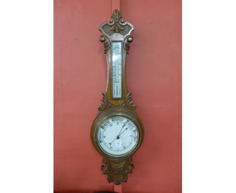 An early 20th Century carved oak aneroid barometer