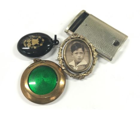 A bag containing a combination match safe cheroot cutter together with a large enamel locket, a gilt metal photograph brooch 