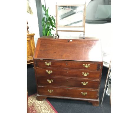 A Georgian mahogany bureau with four graduated drawers, fitted interior, resting on bracket feet.