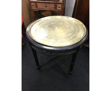 A Benares brass table top mounted on a Chippendale designed circular drawing room table with fret keyed pierced gallery and p