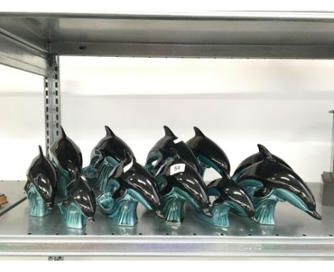 Eleven various blue glazed Poole Pottery dolphins.