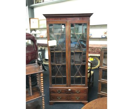 A Chippendale inspired glass fronted astragal glazed display cabinet with fret cut cornice and fitted drawers below.