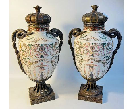 Pair of twin snake handled ceramic urns with enamelled floral decoration and bronzed metal mounts, upon a square base