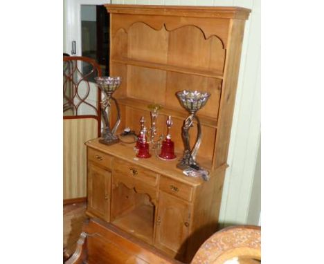 Pine dresser having shelf back above three drawers with central opening and two cupboard doors below