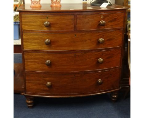 An early mahogany chest fitted with two short and three long drawers, bow fronted on turned legs.