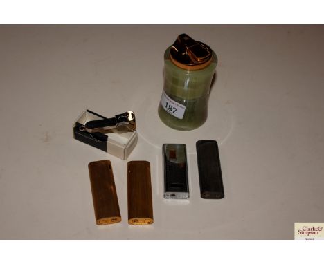 An onyx table lighter, four various other lighters and a boxed cigar cutter