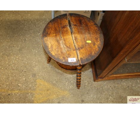 An antique three legged stool raised on bobbin turned supports (top AF)