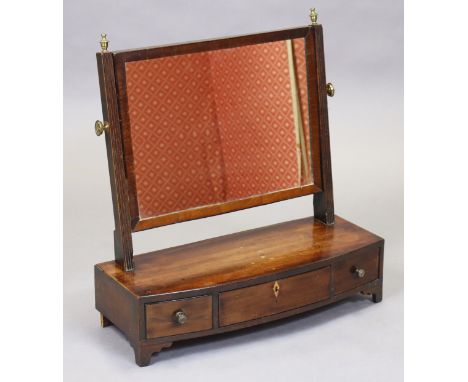 A Georgian mahogany dressing mirror with reeded supports, &amp; bow-front box-base fitted three small drawers, on bracket fee