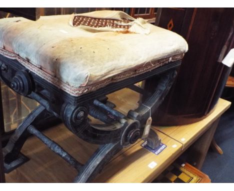 A Victorian ebonised adjustable piano stool raised on an X-frame base with turned cross stretchers and geometric lines
