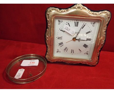 A small silver fronted mantel clock together with a sterling silver and glass coaster