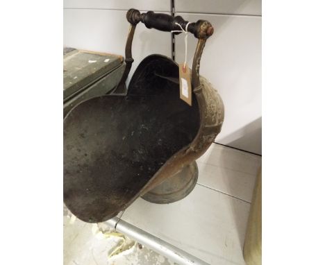A Victorian copper and brass helmet shaped coal scuttle embossed with griffins, flowers and motifs