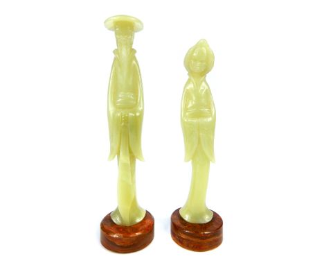 A pair of carved jade figures of a male and female standing in traditional position, each with their arms in folding position