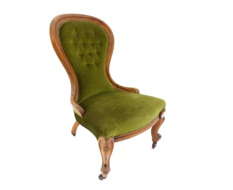 A late Victorian walnut framed spoon back nursing chair, with button back detail, raised on carved cabriole terminating on ca