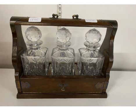 A antique three decanter tantalus with key, shipping unavailable