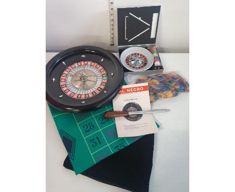 A large roulette wheel with large mat and smaller cased roulette reel.