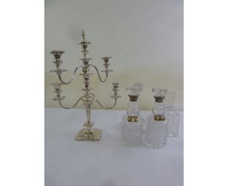 A pair of cut glass decanters with silver collars, two silver wine labels, a silver plated five light candelabrum and two oth