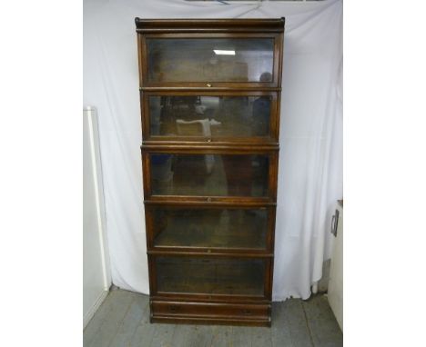 A mahogany five section Globe Wernicke bookcase with glazed hinged doors on raised plinth with single drawer