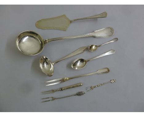 A quantity of silver and white metal flatware to include a ladle, a cake slice, spoons and forks  (9)