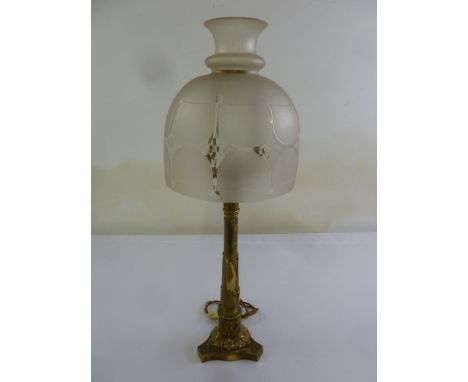 An Art Nouveau brass table lamp with etched glass shade on tri-form base