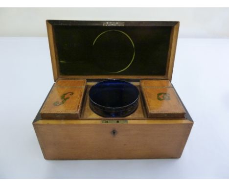 An Edwardian mahogany rectangular tea caddy with satinwood inlays, hinged cover and central blue glass bowl