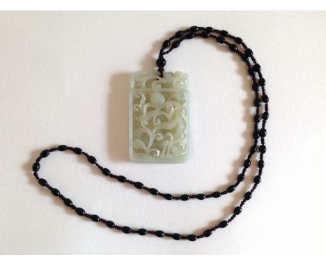 An intricately carved white jade pendant on a beaded necklace. A lovely piece. 4x6cm